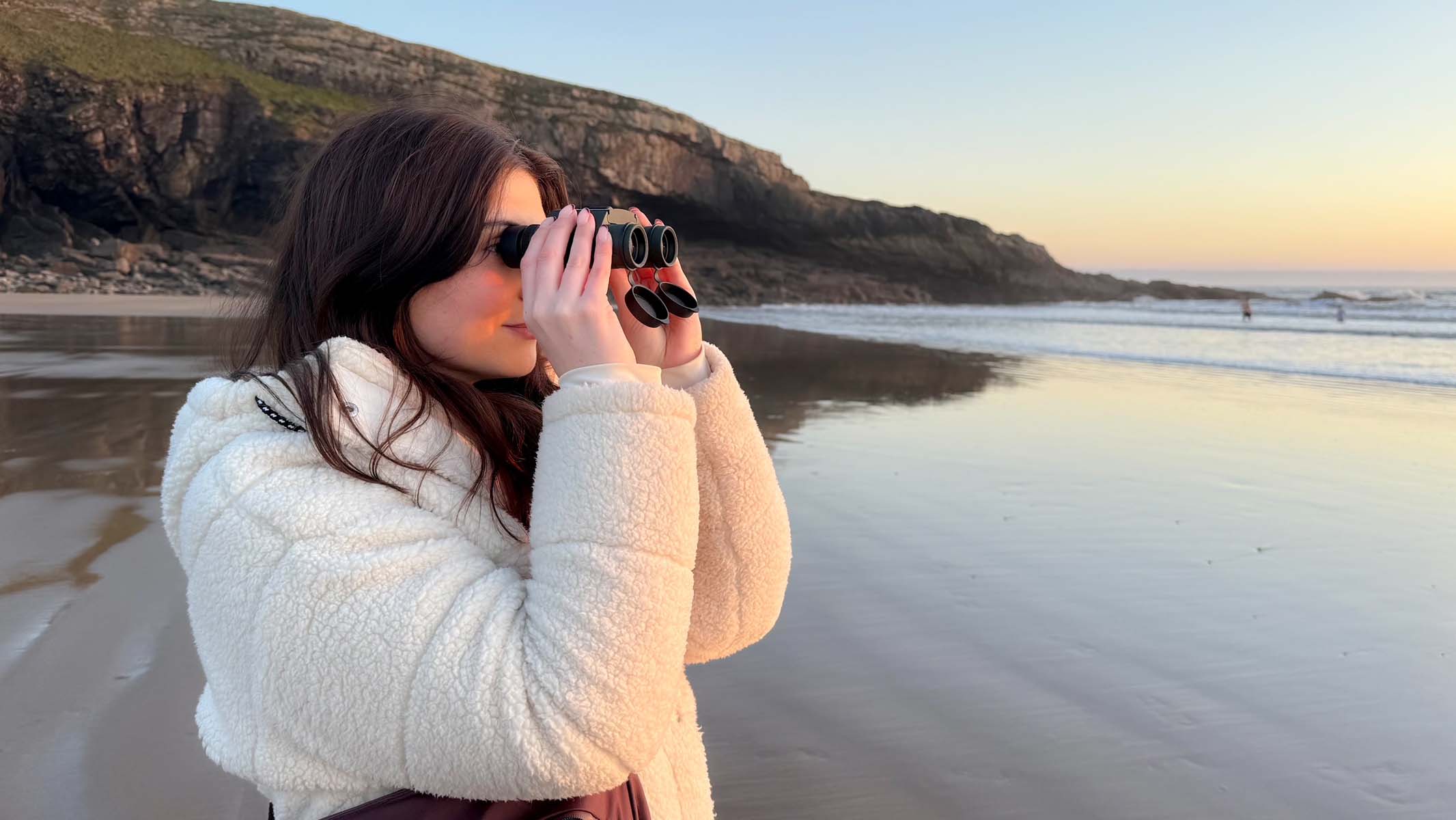 Hawke Endurance ED 8x25 in hand at a coastal location