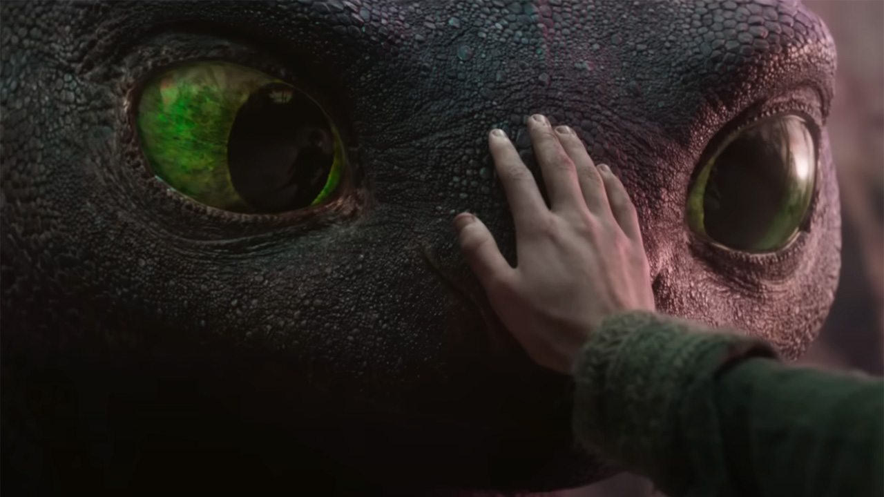 How To Train Your Dragon&#039;s Mason Thames places his hand on dragon Toothless&#039; pebbled black face. 