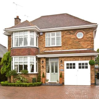 Large detached brick house with white garage exterior