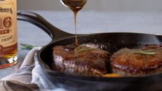 Basting meat with whisky in a cast iron Lodge Skillet 