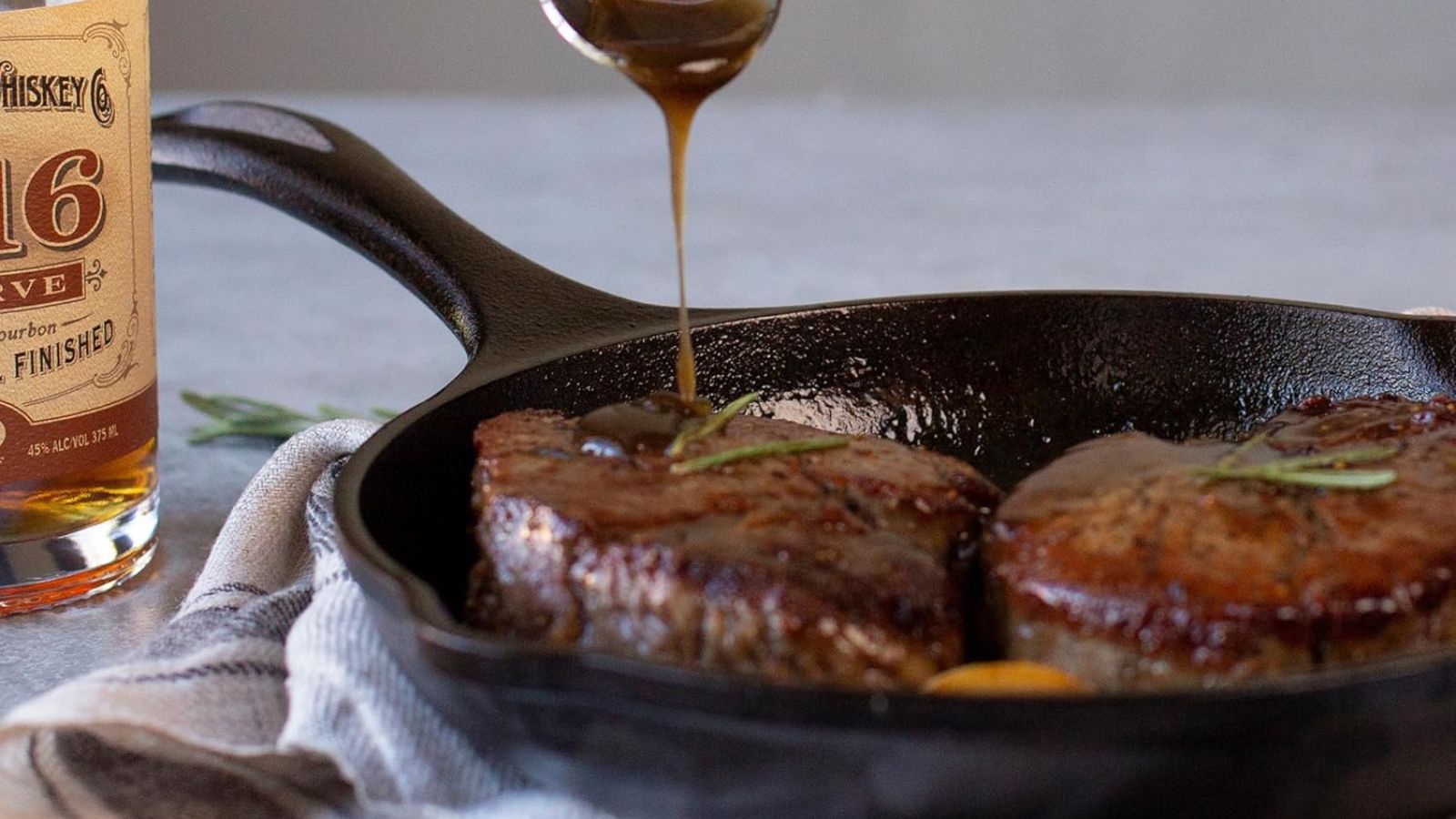 Basting meat with whisky in a cast iron Lodge Skillet 