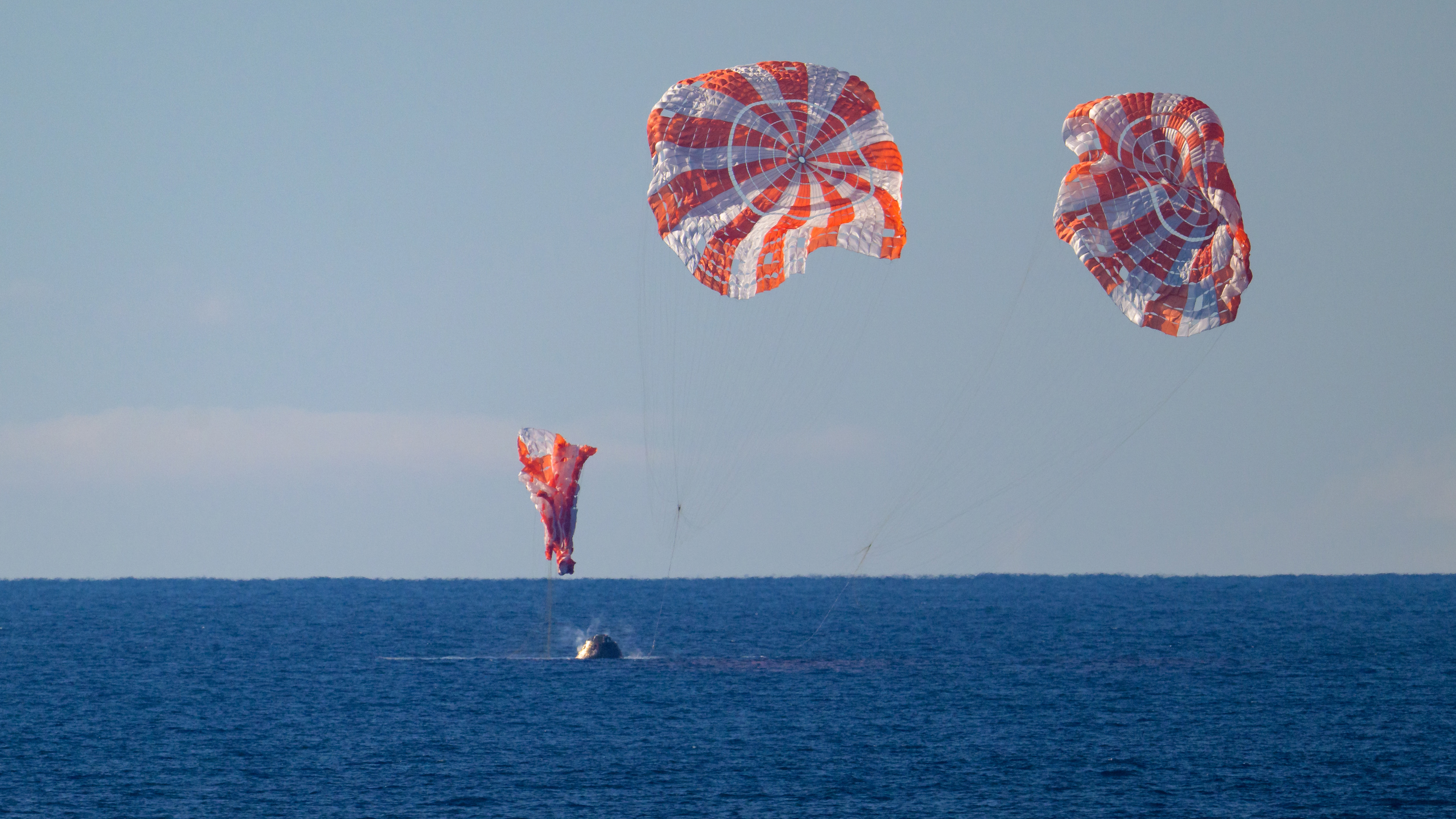 NASA’s Orion spacecraft with Artemis II crewmembers aboard is seen as it lands in the Pacific Ocean off the coast of California, Friday, April 10, 2026