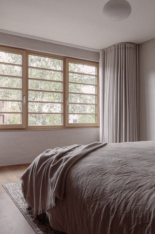 Beige bedroom with beige curtains dressing the window