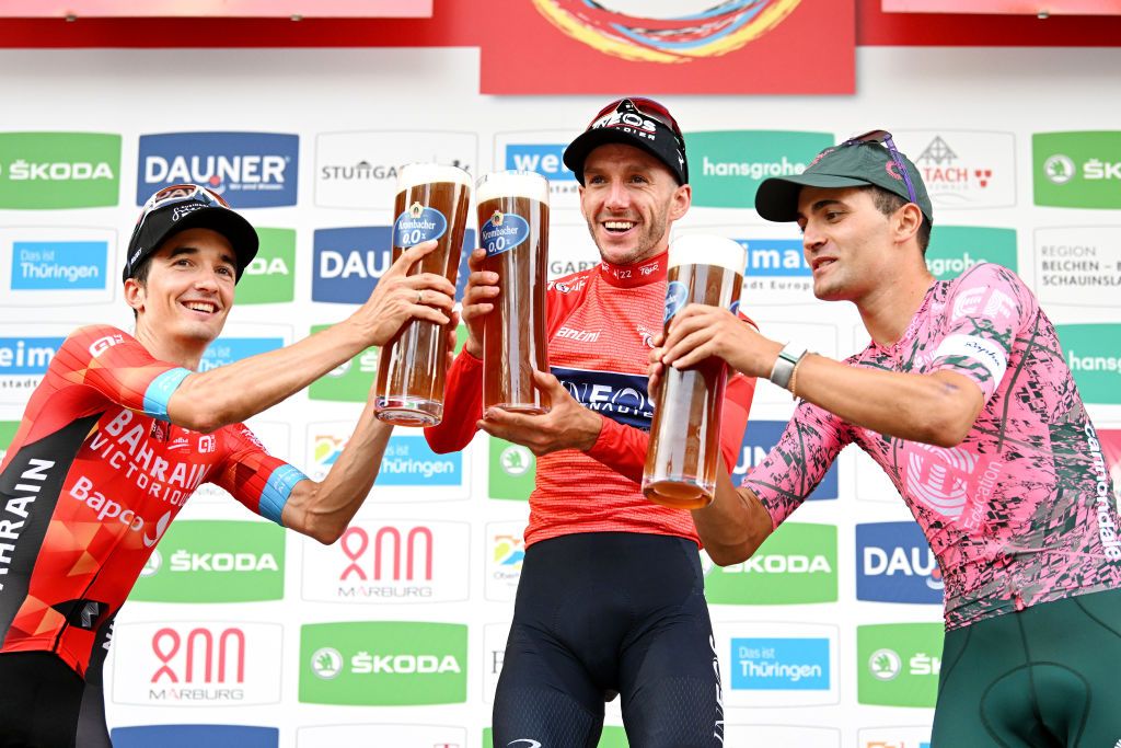 STUTTGART GERMANY AUGUST 28 LR Pello Bilbao Lpez of Spain and Team Bahrain Victorious on second place race winner Adam Yates of United Kingdom and Team INEOS Grenadiers Red Leader Jersey and Ruben Guerreiro of Portugal and Team EF Education Easypost on third place pose and celebrate with a beer on the podium ceremony after the 37th Deutschland Tour 2022 Stage 4 a 1866km stage from Schiltach to Stuttgart DeineTour on August 28 2022 in Stuttgart Germany Photo by Stuart FranklinGetty Images