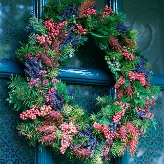 christmas wreath with pink berries on blue window