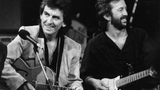 George Harrison (left) and Eric Clapton performing on stage together as part of an all-star band for music legend Carl Perkins, October 23rd 1985