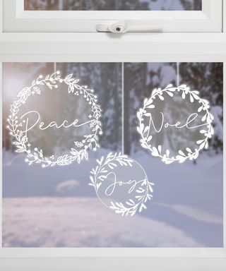 A trio of white wreath-shaped Christmas window display sticker decor