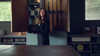 Maya (Michelle Keegan) in front of a wall of guns in Netflix's Fool Me Once