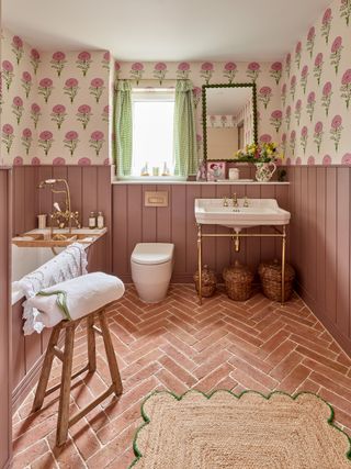 A bathroom with pink wainscoting and Terracotta Parquet floors