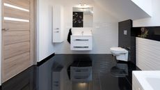 Gleaming bathroom with white wall sink and toilet reflected in shiny black floor tiles - for how to clean bathroom floors