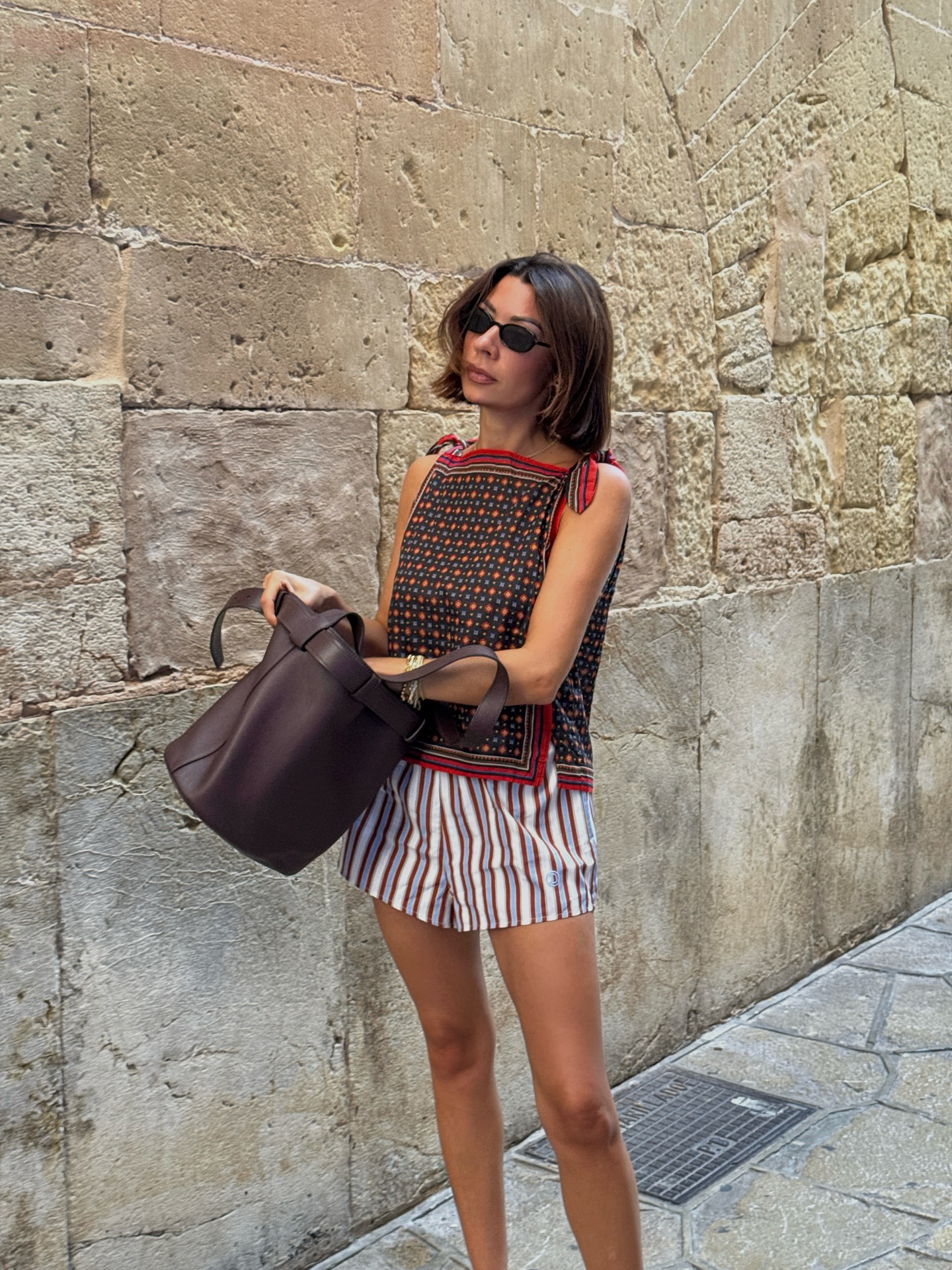 An image of @smythsisters wearing a Doen blouse with striped shorts.
