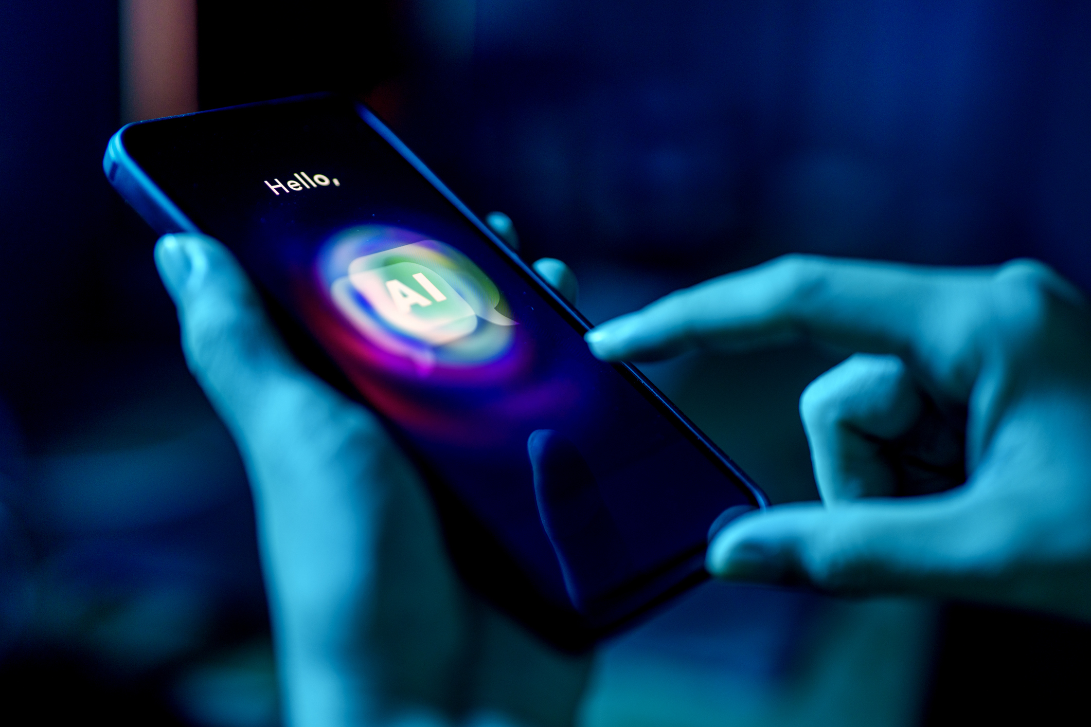 A person using a mobile phone to interact with an AI-powered chatbot, with the screen showing the word AI and vibrant neon lighting in blue tones.