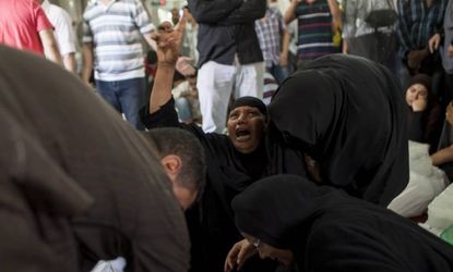 An Egyptian woman identifies the body of a family member, a supporter of deposed Egyptian President Mohammed Morsi killed during a violent crackdown by security forces in Cairo.