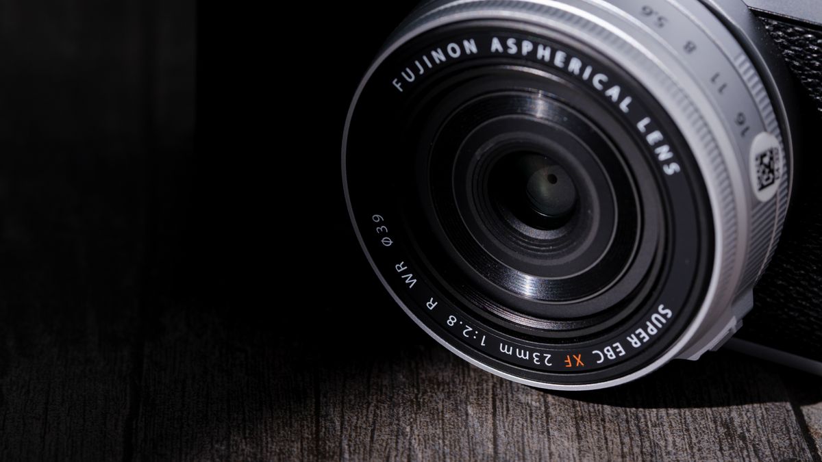 The Fujifilm XF 23mm f/2.8 R WR on a gray wood-like surface