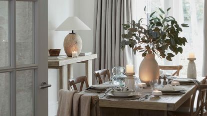 A dining room with large windows in a cool light