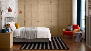 bedroom with built in light wood wardrobes, large window with radiator below