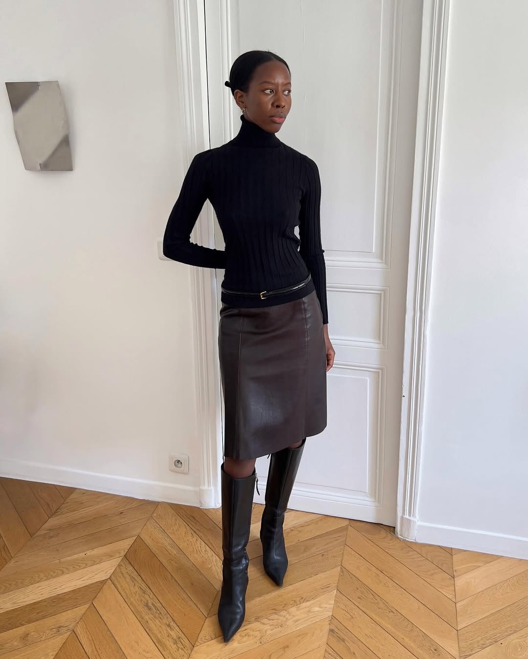 Sylvie wearing a turtleneck and leather skirt