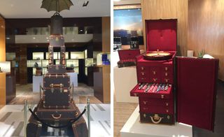 Left, a display of stacked luggage with an umbrella at the top of it. Right, a brown portable roulette trunk with the wheel on top and red drawers with chips in below.