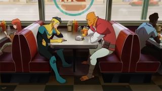 Still from the adult animated superhero T.V. show Invincible. Here we see 17-year-old superhero Invincible (opaque lens over his eyes, short dark hair slicked back, yellow, black and green superhero suit) sitting at a diner booth with his large orange alien friend who is drinking from a fast food cup. Invincible is busy scrolling on his phone.