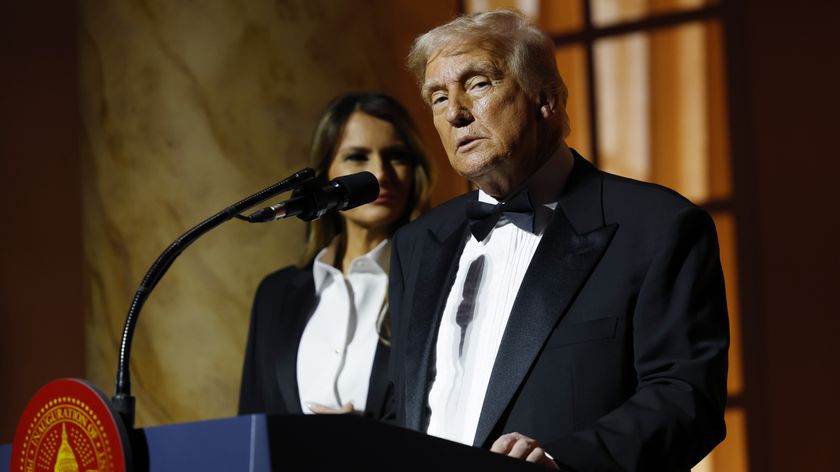 Donald Trump speaks at a lectern during a black tie dinner