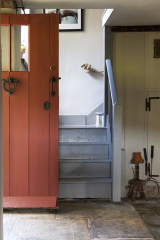 red wooden front door opening into hallway