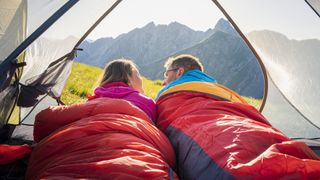 Couple lying down in a tent on the mountains