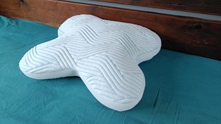 The Tempur Ombracio Smartcool Pillow on a bed with teal sheets, being tested