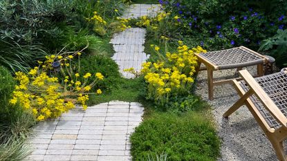 a garden with a stacked bond rectangular paver path