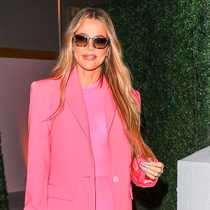 Khloe Kardashian in a pink monochromatic suit with long, wavy extensions