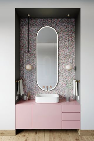 Pink cabinets, backlit mirror with gold taps
