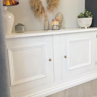 white cupboard with potted plant and lamp