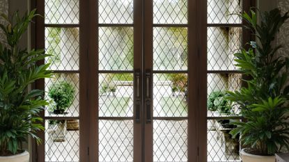 Grand French doors overlooking a garden area, layered with peel-and-stick diamond grid window film by Chris Loves Julia x WallPops