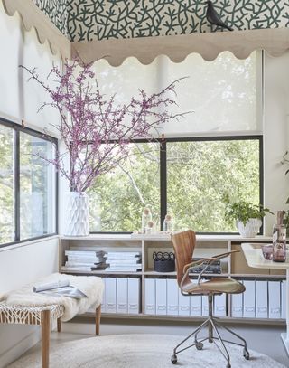 Small home office with large windows and wallpapered ceiling