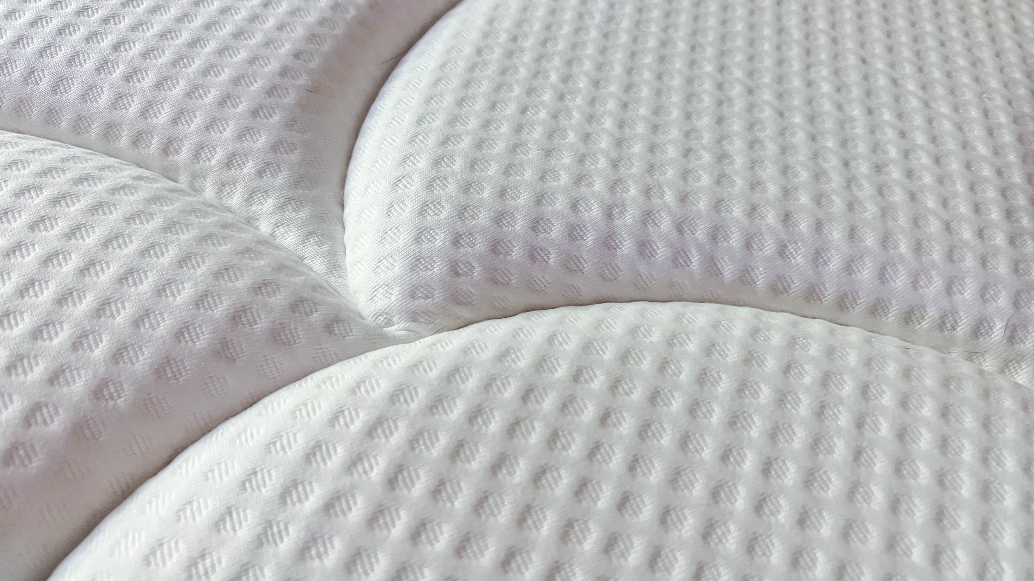 Image shows a close up of our review sample of the DreamCloud Premier Hybrid mattress and the plush euro top