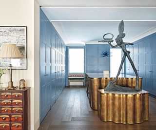 Blue cupboards, wooden floor, statue, gold worktop