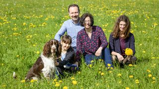 English springer spaniel with human family in a meadow