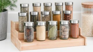 organizing kitchen countertops with wooden stylist spice rack beside cooking area