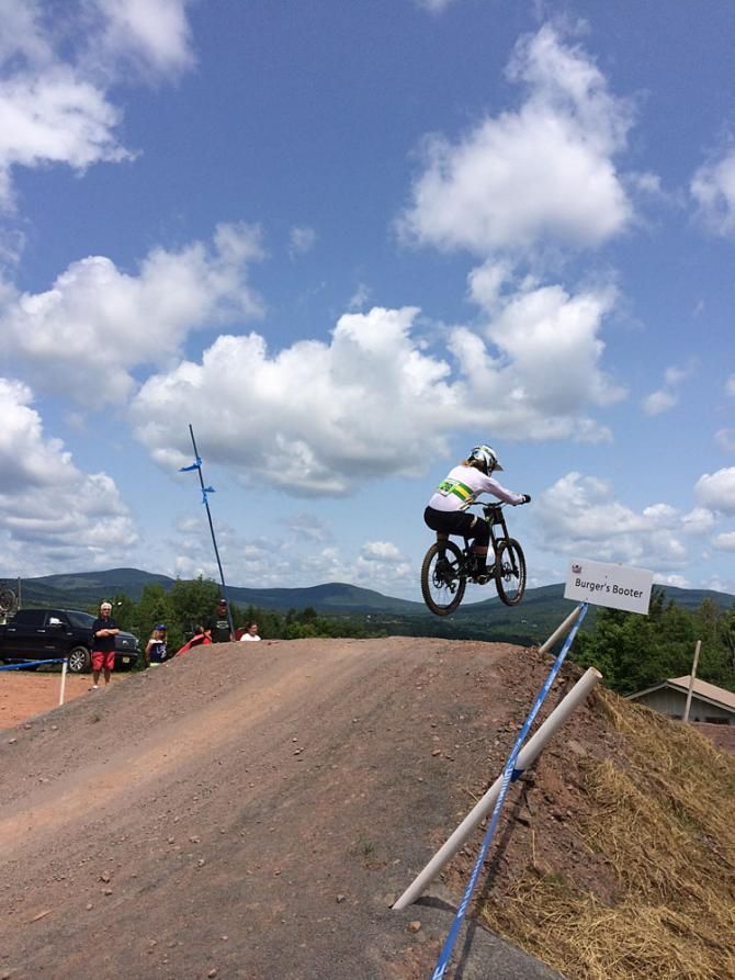 An Australian junior downhiller goes airborne on a jump during qualifying