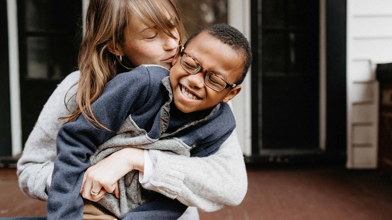 A young mom nuzzles her adopted son.