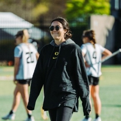 female trainer walks on lacrosse field