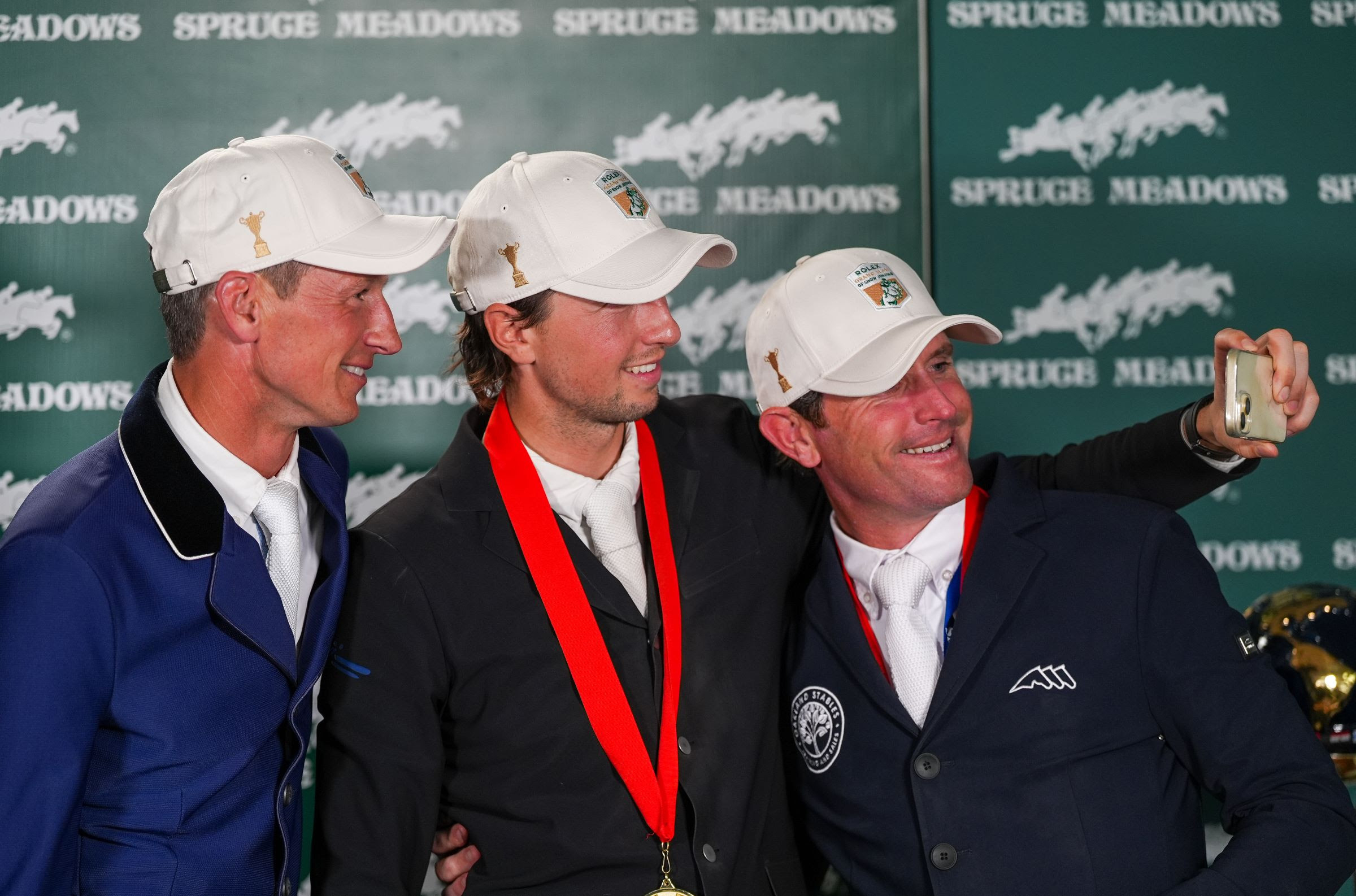 Daniel Deusser, Martin Fuchs and Darragh Kenny pose for a selfie after finishing top three in the CPKC International at Spruce Meadows.