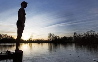 A swimmer prepares to plunge