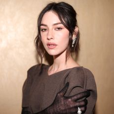 Gracie Abrams wears a brown dress with mesh gloves.