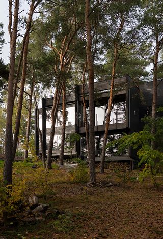 hero exterior of cabin peeking between trees at Villa Nikkesmelle by Gartnerfuglen