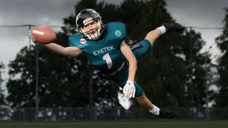 American football player, diving to catch ball