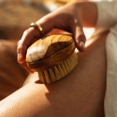 person dry brushing with the altesse body brush