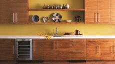 Yellow walls with mid-century modern cabinetry, open shelving, artisanal ceramics, white countertops