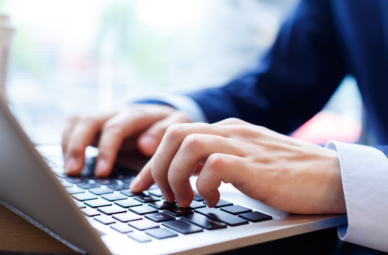 close up view of businessman typing on laptop indoors