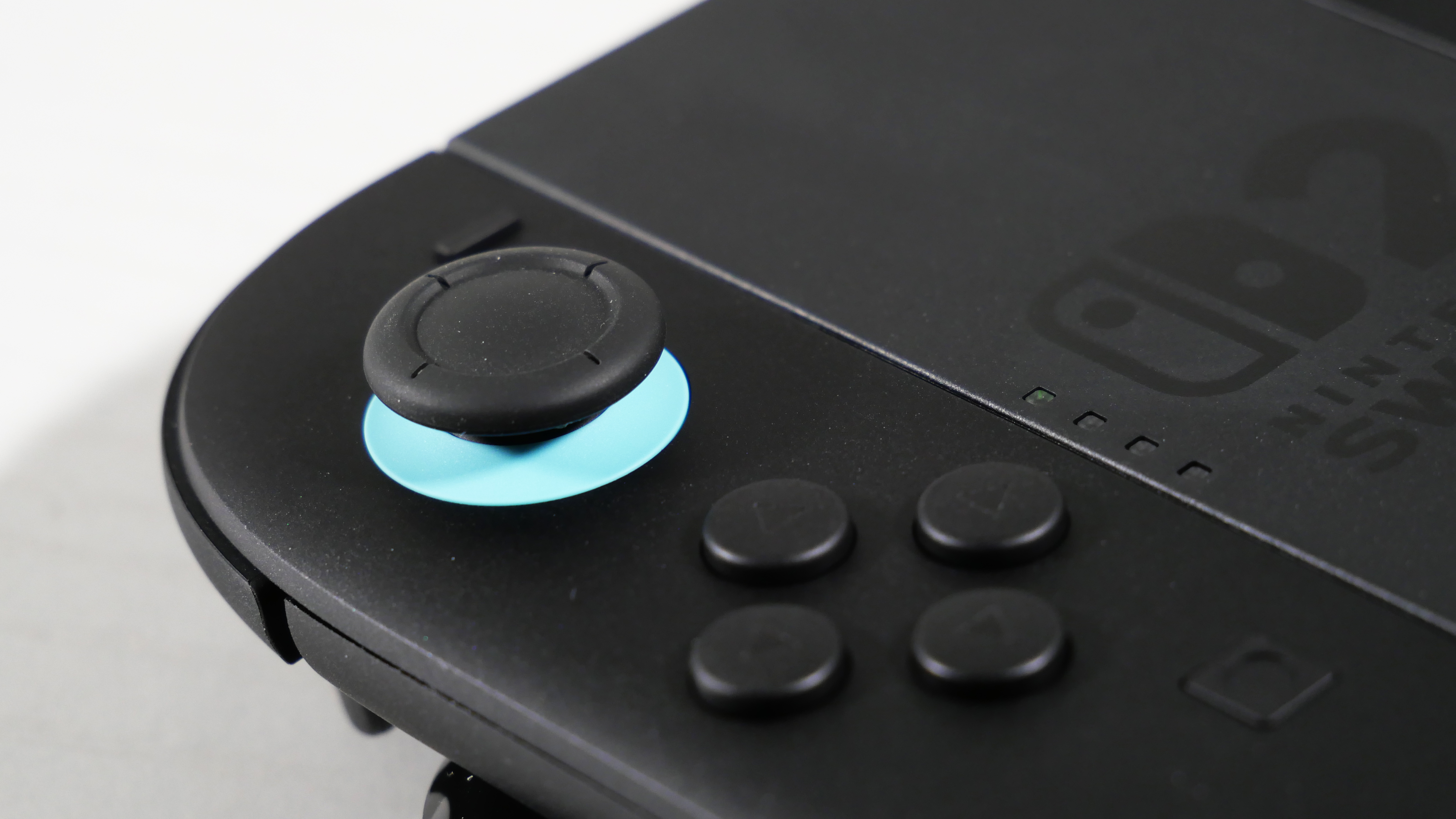 Nintendo Switch 2 Joy-Con 2 Grip laying on a white desk, highlighting its Blue Analog Stick.