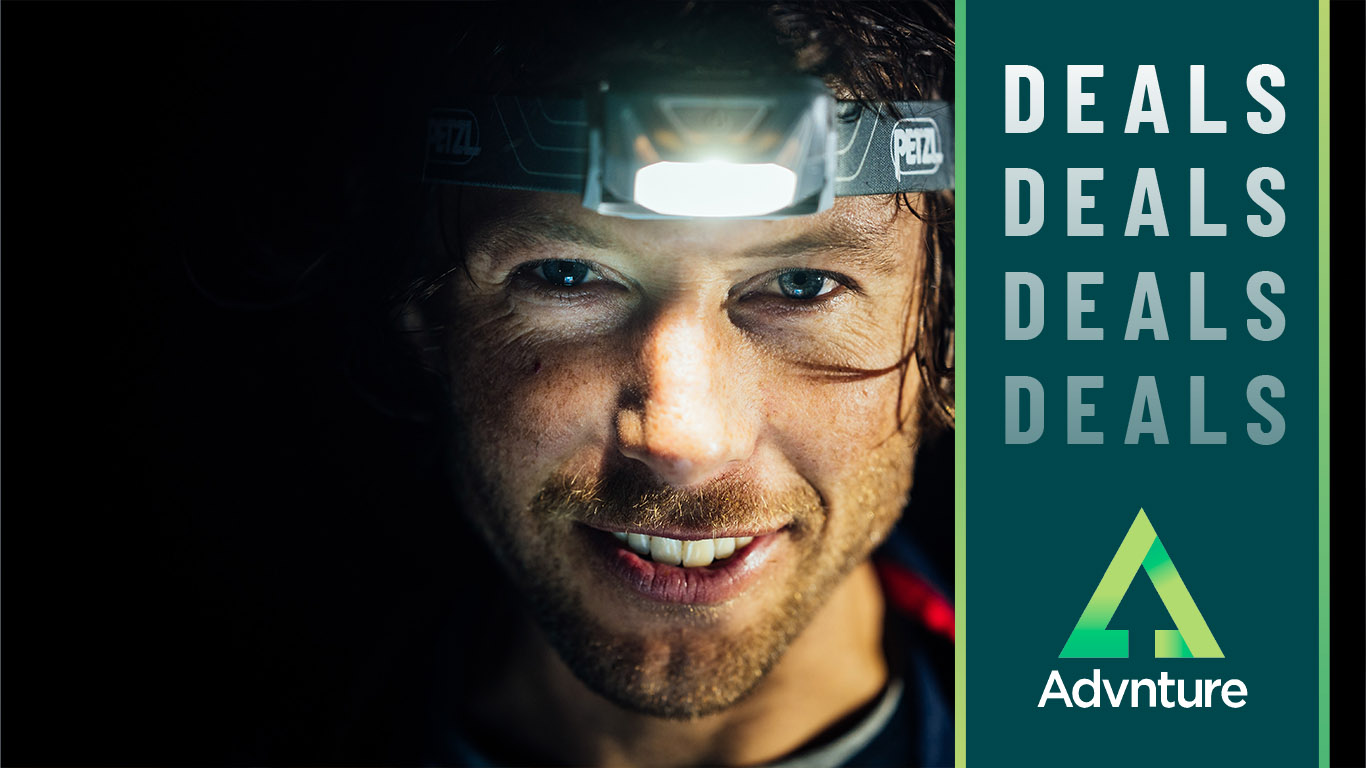 Deals image showing hiker wearing Petzl Tikkina headlamp